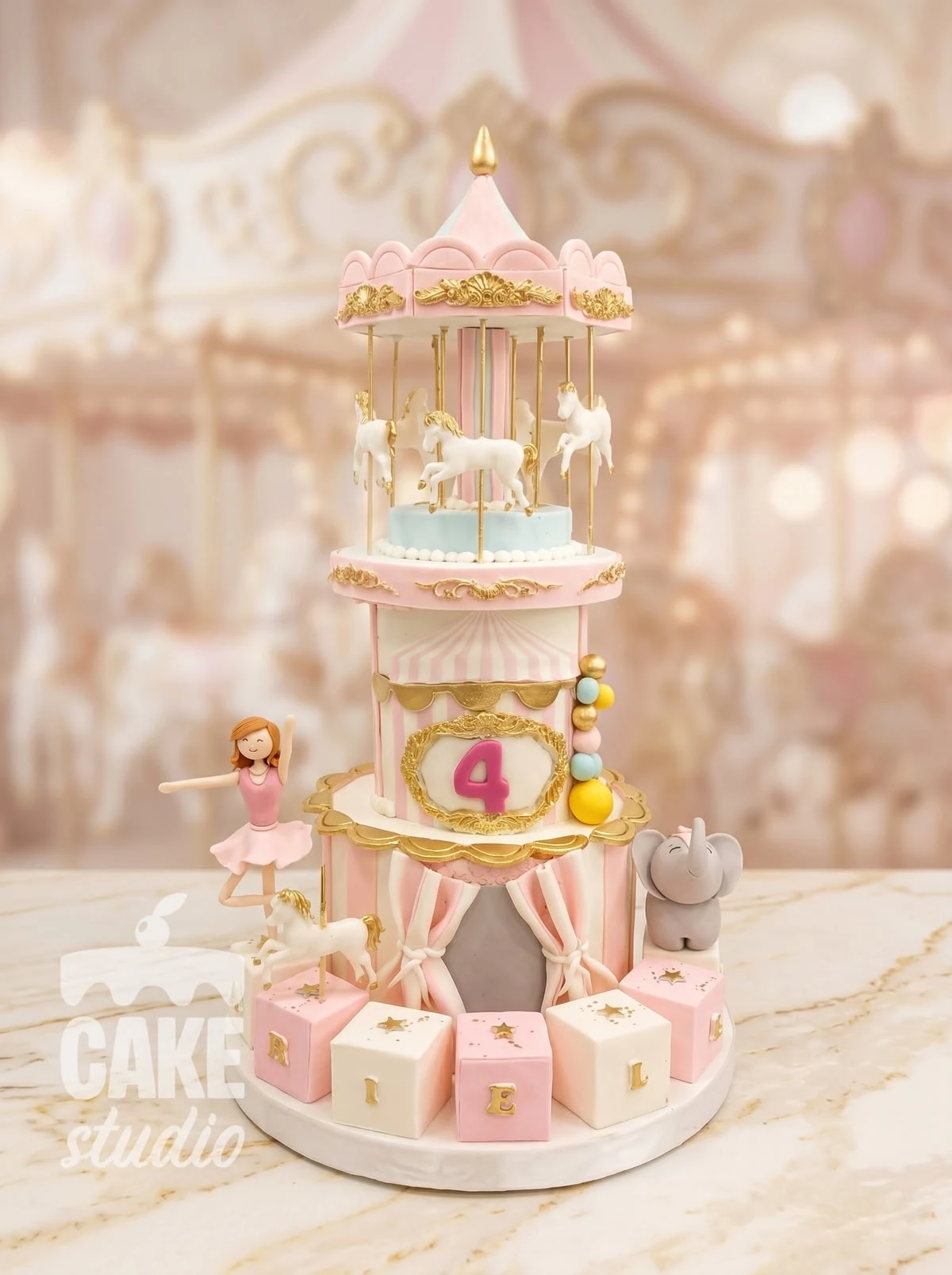 Pastel con carrusel, caballos y elefante en tonos rosa y dorado, elaborado por Cake Studio